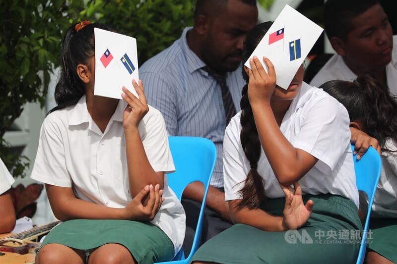 圖為總統蔡英文2019年3月出訪諾魯，當地歡迎儀式表演學生因天氣炎熱拿起印有兩國國旗的手冊遮陽。（中央社檔案照片）